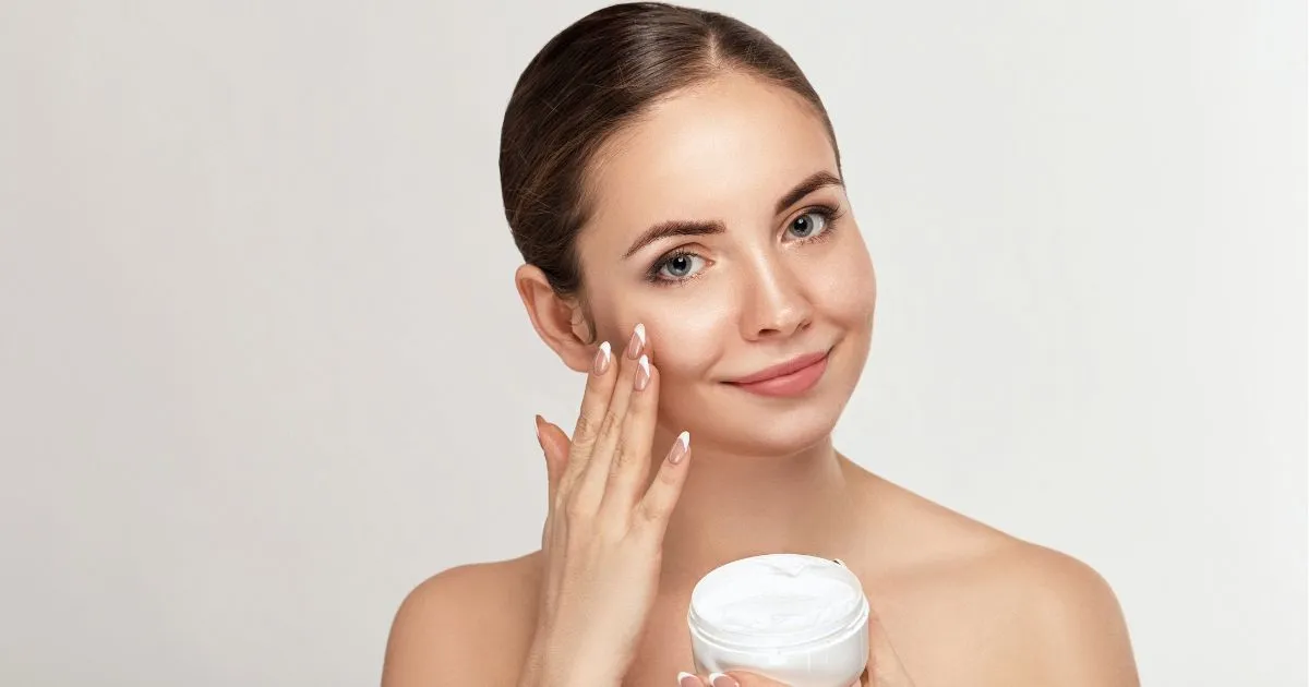 A woman with flawless skin applying cream during her Regular Facial in Middletown, NY